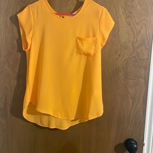 This is a bright orange top great way to spice up a plain outfit.